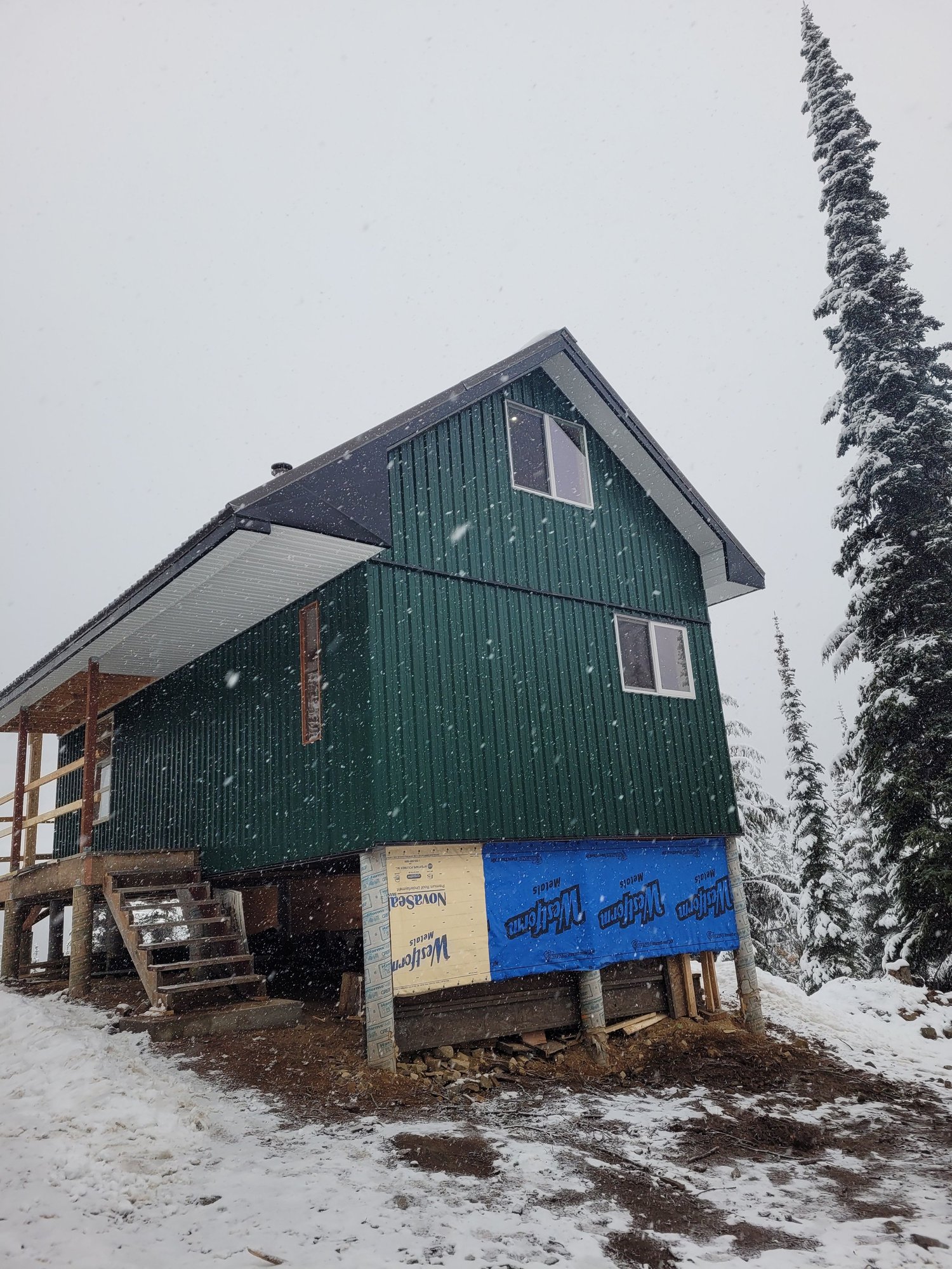 The finished cabin in falling snow